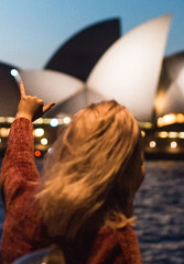 Tourist in front of Sydney Opera House on a night tour of Sydney Harbor