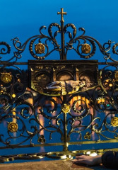 Tourist looking at the love locks on Charles Bridge while exploring Prague on a night tour
