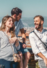 Tourists standing in the sunshine with their local guide at a viewpoint in Florence