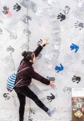 Tourists having fun with the street art along Berlin Wall 