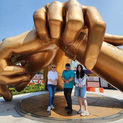 Golden Moments: Striking a Pose Under Giant Hands