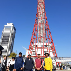 Group of people standing in front of Kobe Port Tower in Japan.