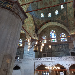 Interior view of the Yeni Mosque in Istanbul, showcasing intricate ceiling designs.