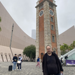Historical clock tower at Tsim Sha Tsui, Hong Kong alongside visitors.