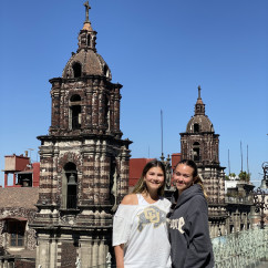 Close-up of cathedral towers in Puebla with two people nearby.