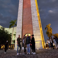 Clock tower at night with clouds in the background.
