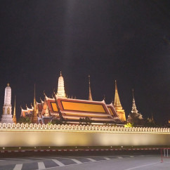 Temple of the Emerald Buddha at night with illuminated spires and wall.