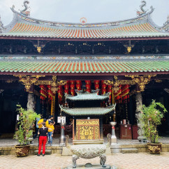 A family visits Thian Hock Keng Temple, showcasing intricate carvings and red lanterns.