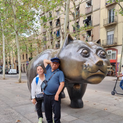 Two people stand beside the sculpture El Gato de Botero in Barcelona.