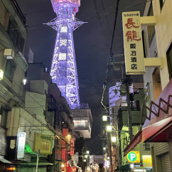 Tsutenkaku Tower illuminated at night in Osaka, Japan.