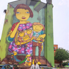 Large mural in Västerås, Sweden, with two cars parked below.