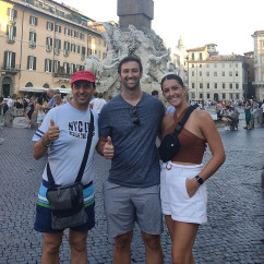 Three people posing in front of the Fountain of the Four Rivers, Piazza Navona.
