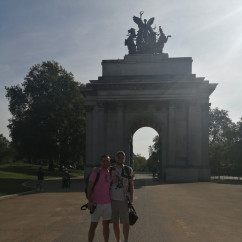 Two people standing in front of the Wellington Arch in London.
