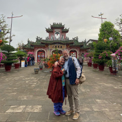 Two people standing in front of the Phuc Kien Assembly Hall entrance.