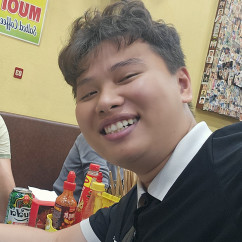 Woman and man posing for a selfie inside a small eatery.