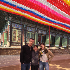 Three people standing in front of Jogyesa Temple in Seoul, South Korea.