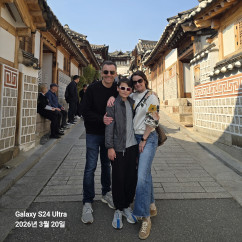 Three people stand on a traditional street in Seoul.
