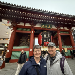 Visitors posing near the large red lantern of Kaminarimon Gate, Tokyo.