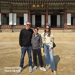Visitors in casual attire at a historic palace entrance in South Korea.