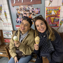 Two women enjoy ice cream at a bench inside a Japanese dessert store.