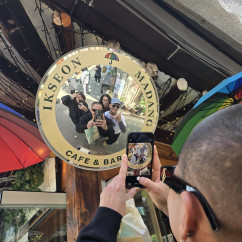 People taking a selfie in a circular mirror at Madang Ikseon Cafe.