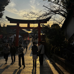 People walking through a torii gate at Fushimi Inari Shrine, Kyoto, Japan.
