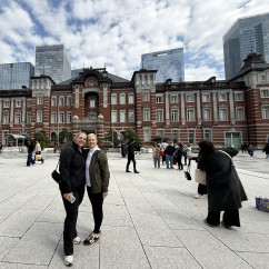 People standing in front of Tokyo Station with skyscrapers in the background.