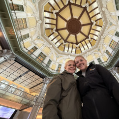 Upward view of Tokyo Station's interior dome with two people underneath.