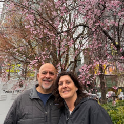 A couple enjoys the cherry blossoms on a cloudy Tokyo day.