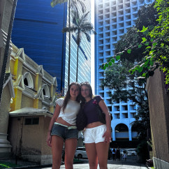 Tourists strolling under the skyscrapers in Hong Kong's midday sun.