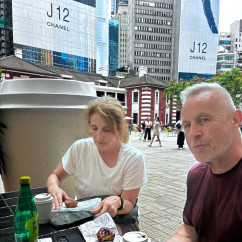 Tourists enjoying a quiet moment with coffee in bustling Hong Kong.