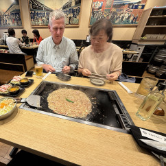 Steam rises from a sizzling okonomiyaki in Tokyo's cozy eatery.