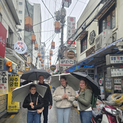 Enjoying a rainy day adventure in a vibrant Seoul neighborhood.