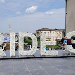 Pausing by the large installation, the city buzzes around.