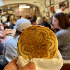Sharing a warm pastry moment in vibrant Bologna.