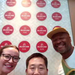 Smiles all around in front of a Michelin wall in Hong Kong.
