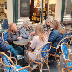 Friends share stories over coffee at a Brussels café.