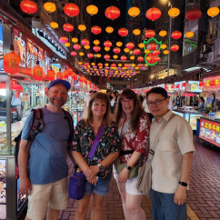 Strolling under vibrant lanterns in a lively Hong Kong street market.
