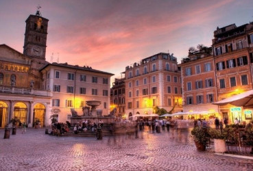 Tourists exploring the nightlife of a piazza in Rome with a local guide