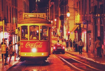 Tourists boarding a tram in Lisbon on a night out exploring the city's nightlife