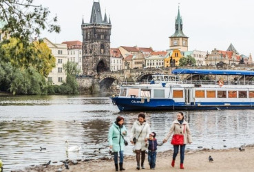 Family exploring the riverbank of the Vltava river in Prague with a local guide