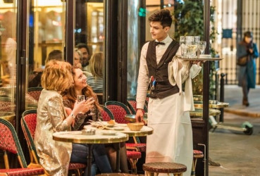 Tourist and a local enjoying a light dinner at a bistro in Paris