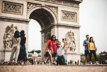 Tourists posing in front of Arc de Triomphe in Paris