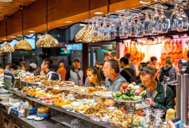 Tourists enjoying dinner at Mercat de la Boqueria on a food tour in Barcelona