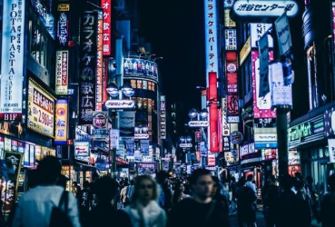 Walking down a busy, neon-lit street in Tokyo on a night tour of the city