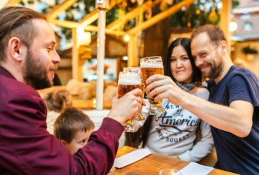 Tourist couple enjoying a local beer with their guide while on a family tour of Prague