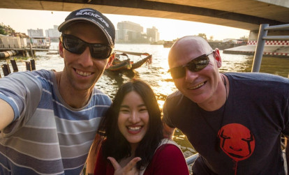 Tourists on a river cruise along Chao Phraya River with a Bangkok local guide