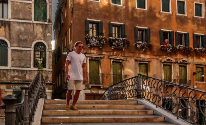 Tourist walking down steps on an evening tour of Venice