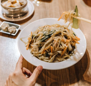 Bowl of Soba noodles and someone using chopsticks