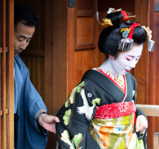 Geisha walking out of a traditional wooden structure